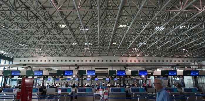 Airport check-in hall with passengers queueing during peak hours