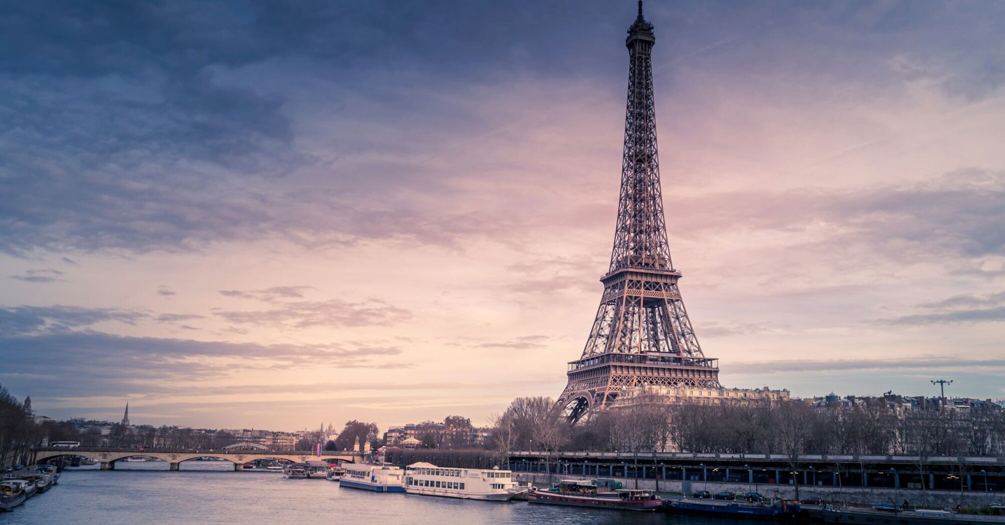 Eiffel Tower at sunset with boats on the Seine in Paris
