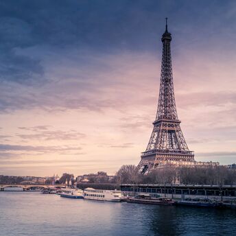 Eiffel Tower at sunset with boats on the Seine in Paris