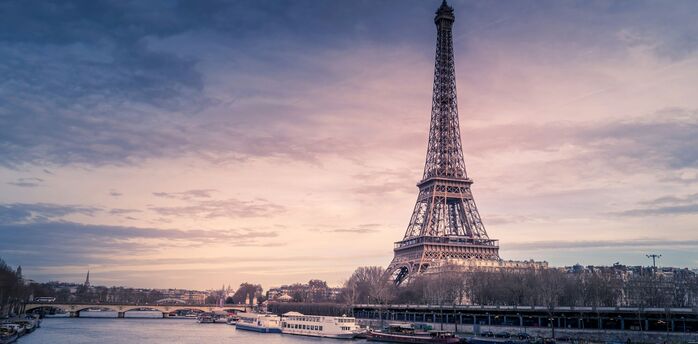 Eiffel Tower at sunset with boats on the Seine in Paris