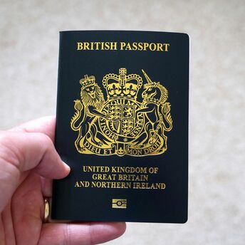 Hand holding a British passport