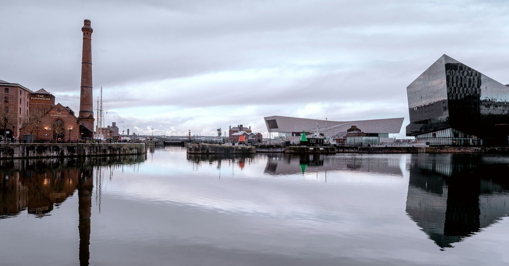 Waterfront docks with historic and modern buildings reflected in calm water