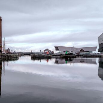 Waterfront docks with historic and modern buildings reflected in calm water