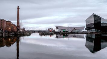 Waterfront docks with historic and modern buildings reflected in calm water