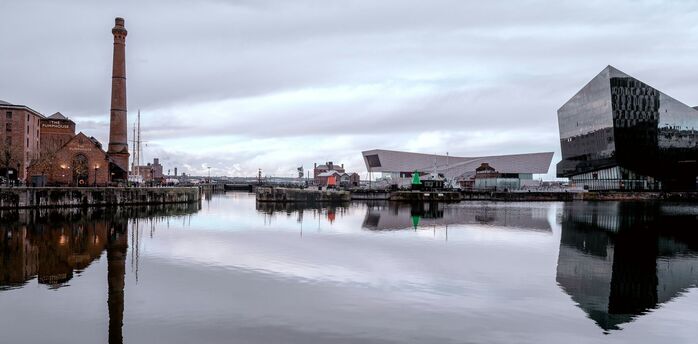 Waterfront docks with historic and modern buildings reflected in calm water