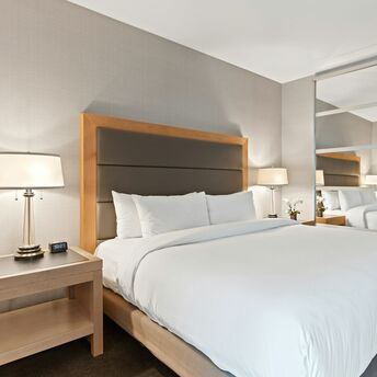 Contemporary hotel bedroom with large bed and mirrored wardrobe