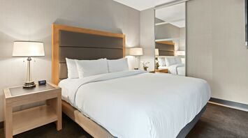Contemporary hotel bedroom with large bed and mirrored wardrobe