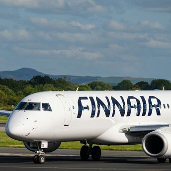 Finnair Embraer aircraft taxiing on runway at regional airport