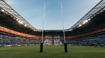 Rugby supporters holding scarf inside packed stadium