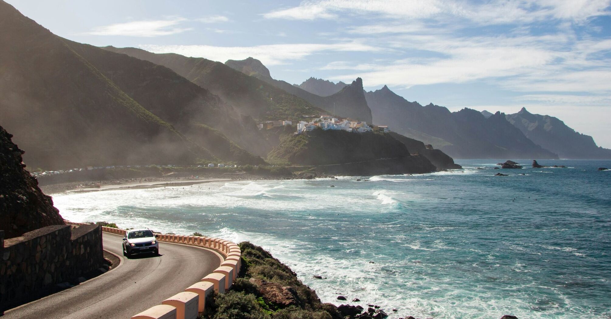 Coastal road and beach in Tenerife with mountains in background