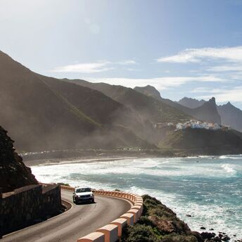 Coastal road and beach in Tenerife with mountains in background