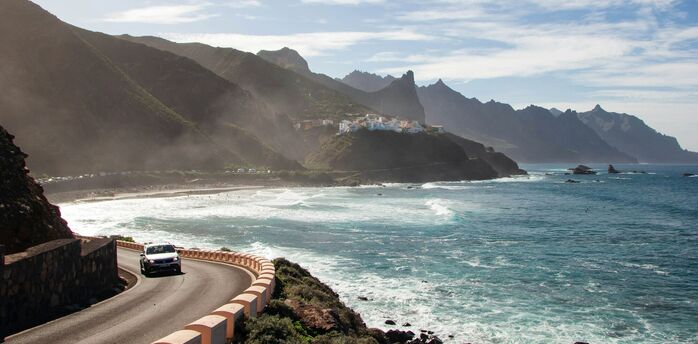 Coastal road and beach in Tenerife with mountains in background
