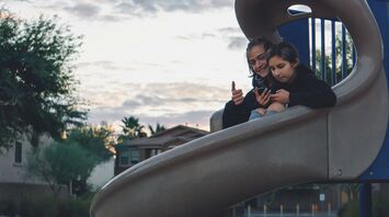 Children sitting on playground slide outdoors