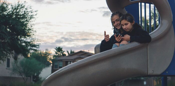 Children sitting on playground slide outdoors