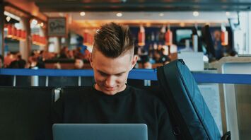 Passenger browsing travel content while waiting at airport