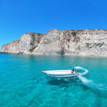 Boat sailing along Crete coastline near cliffs