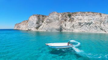 Boat sailing along Crete coastline near cliffs