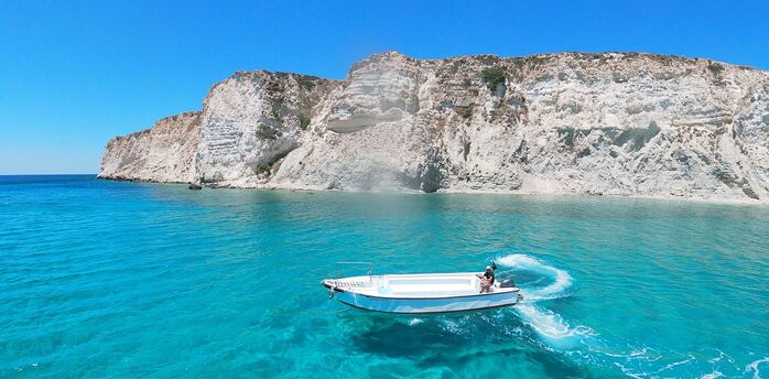 Boat sailing along Crete coastline near cliffs