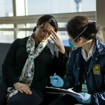 Health worker assessing unwell traveller