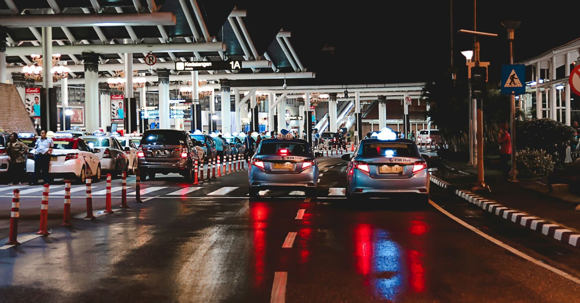 Cars queuing outside an airport terminal at night
