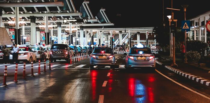 Cars queuing outside an airport terminal at night