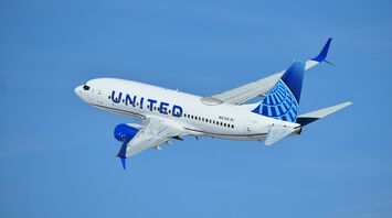 United Airlines aircraft flying in clear blue sky