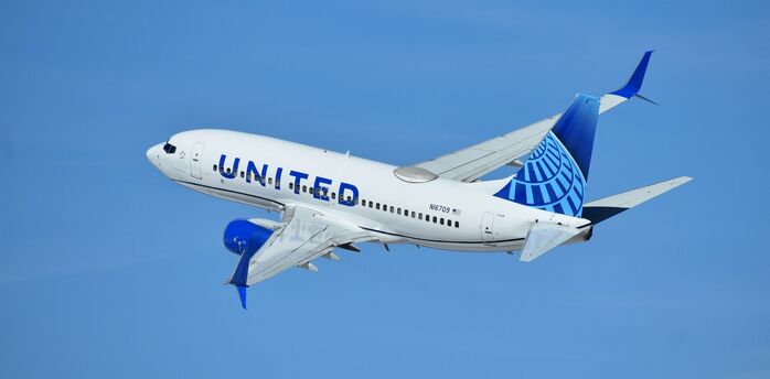 United Airlines aircraft flying in clear blue sky