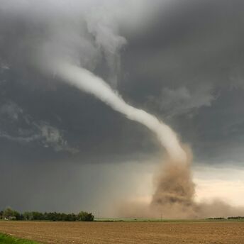 Tornado funnel cloud over open farmland