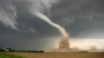 Tornado funnel cloud over open farmland