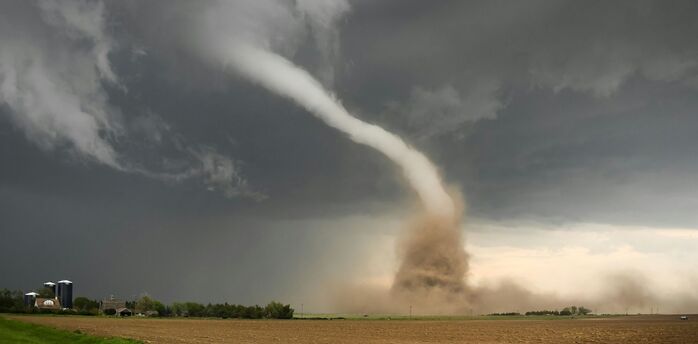 Tornado funnel cloud over open farmland