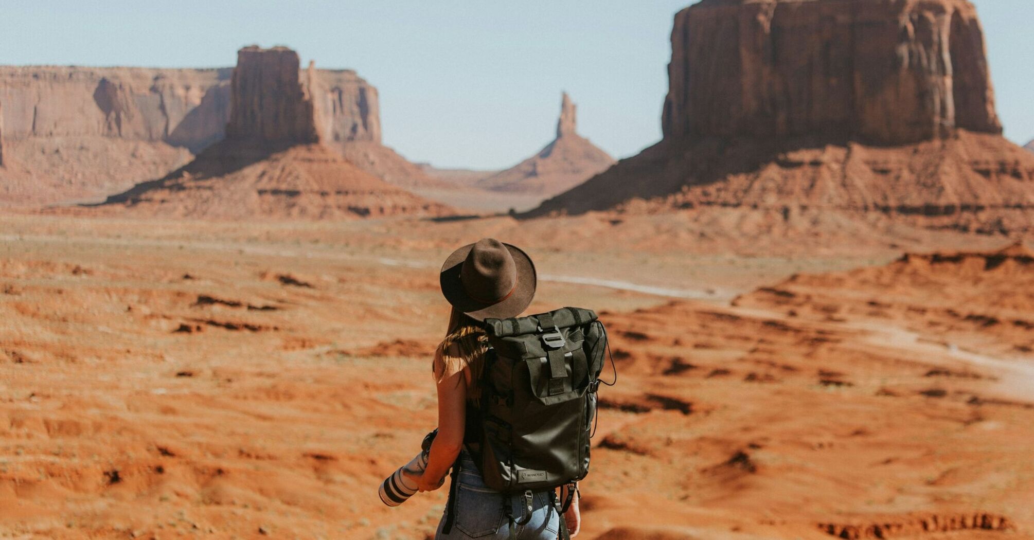 Traveller standing in Monument Valley desert landscape