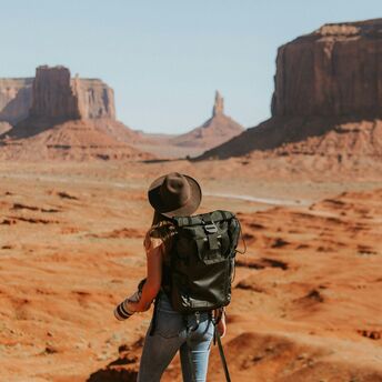 Traveller standing in Monument Valley desert landscape