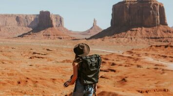 Traveller standing in Monument Valley desert landscape