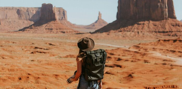 Traveller standing in Monument Valley desert landscape