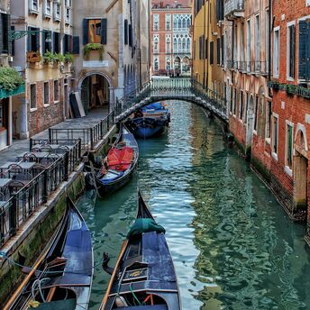 Gondolas moored along a narrow canal in Venice