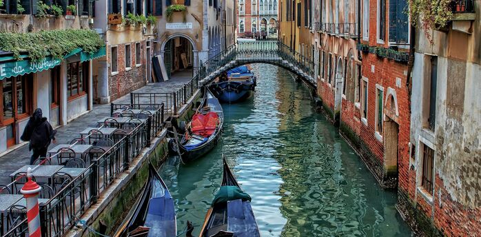 Gondolas moored along a narrow canal in Venice