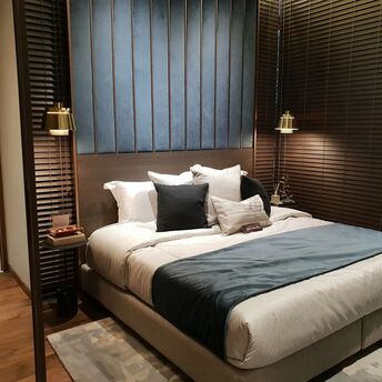 Modern hotel bedroom with large bed and warm lighting