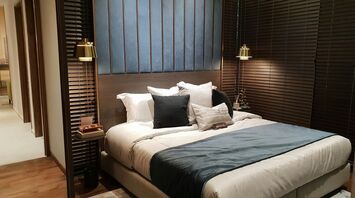 Modern hotel bedroom with large bed and warm lighting