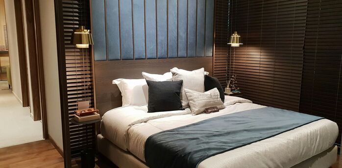 Modern hotel bedroom with large bed and warm lighting