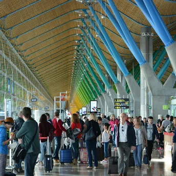 Busy airport terminal with travellers walking through departure hall