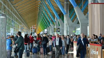 Busy airport terminal with travellers walking through departure hall