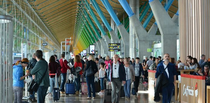 Busy airport terminal with travellers walking through departure hall