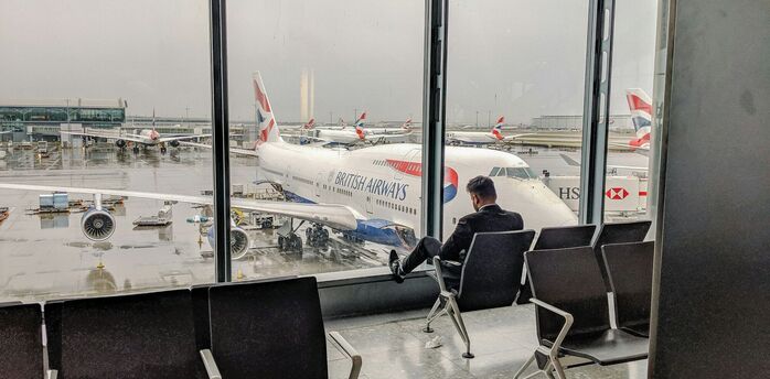Passenger waiting at Heathrow terminal overlooking British Airways aircraft