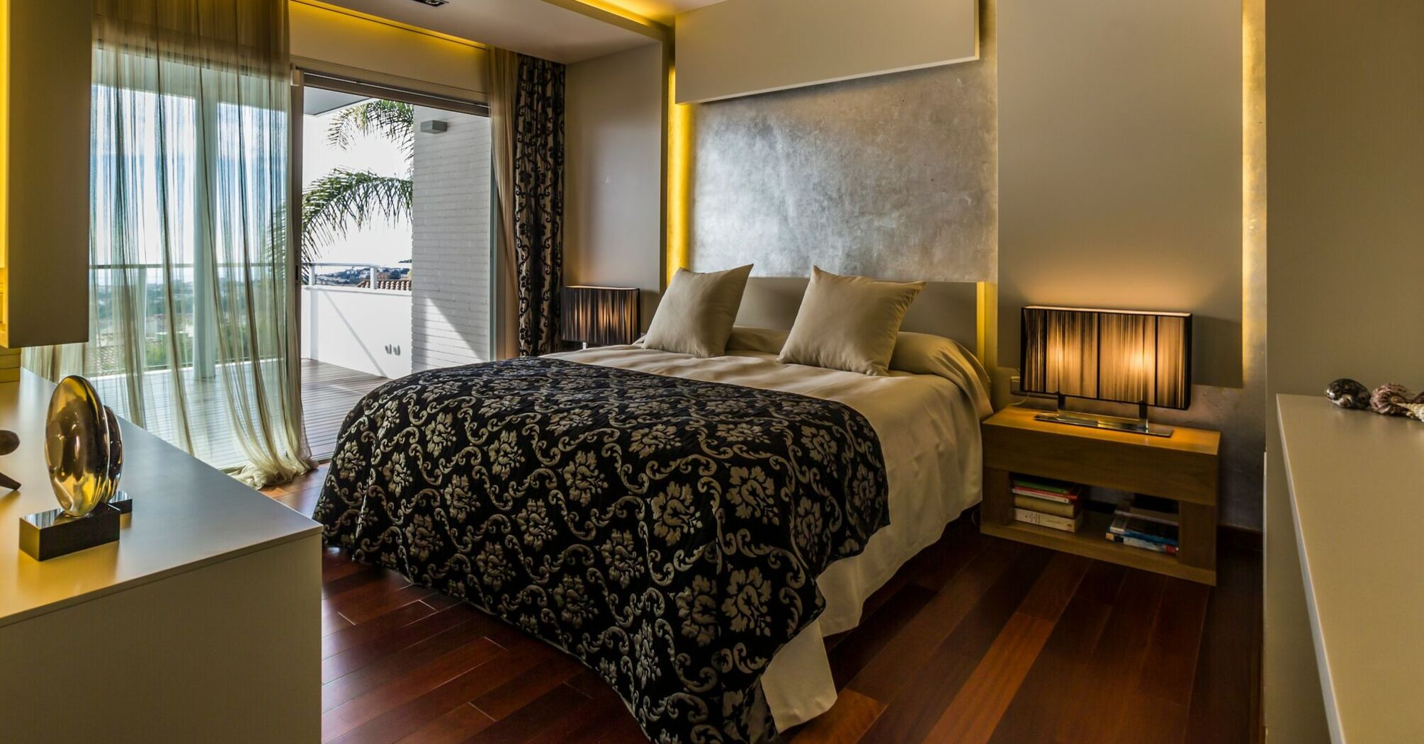 Modern hotel bedroom with balcony and warm lighting