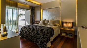 Modern hotel bedroom with balcony and warm lighting
