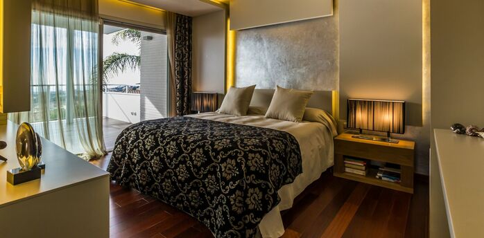 Modern hotel bedroom with balcony and warm lighting