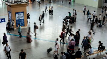 Busy airport terminal with passengers moving through departures hall