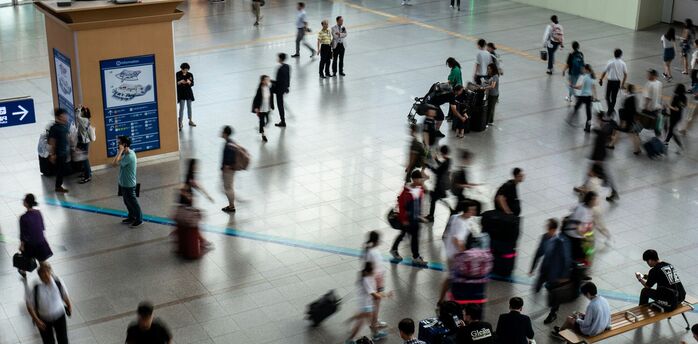 Busy airport terminal with passengers moving through departures hall
