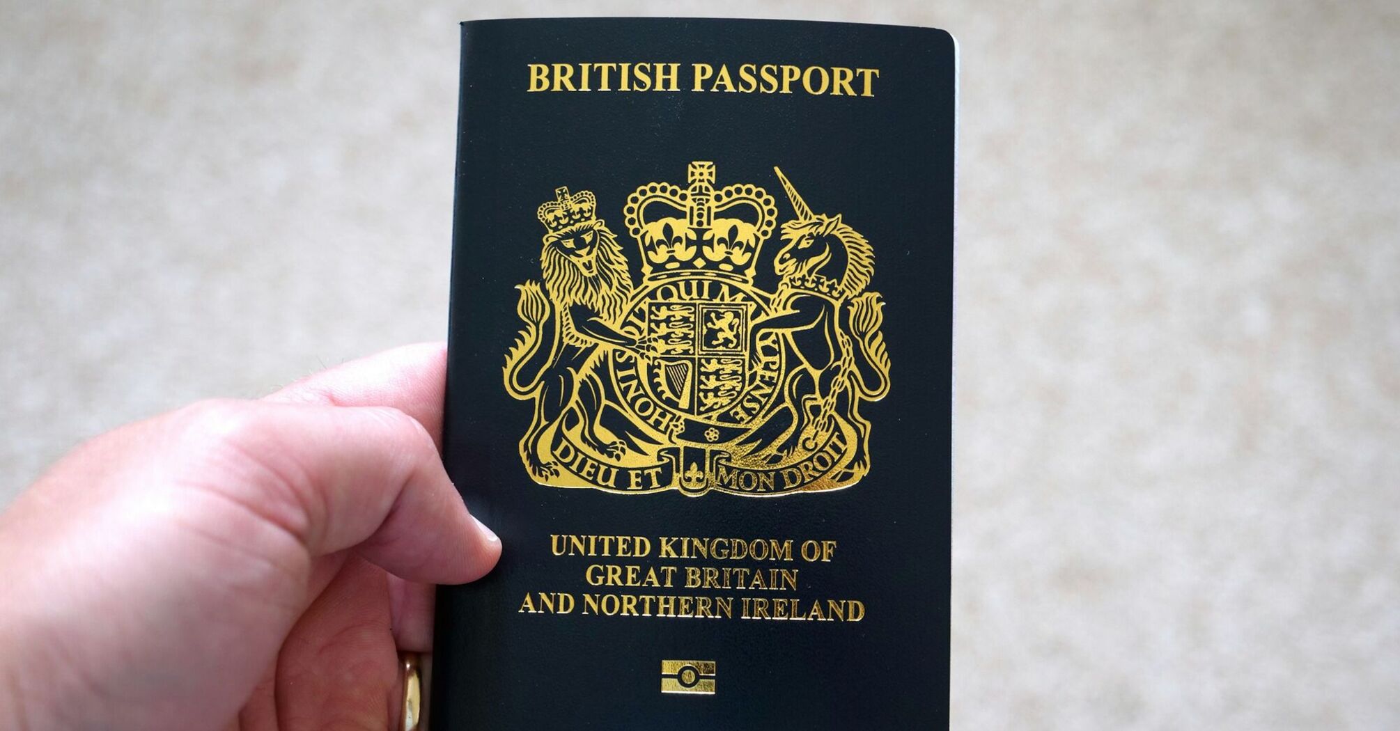 Hand holding a British passport close up