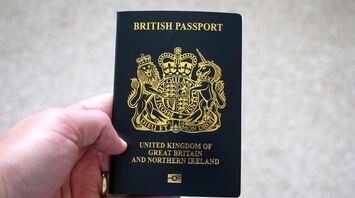 Hand holding a British passport close up